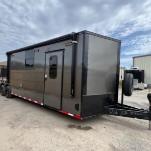A gray 8.5x30TA hybrid enclosed trailer, shown from a front-side angle to highlight its dual-purpose design.