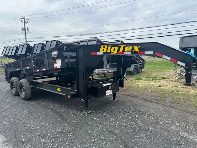 Big Tex 7 x 16 Gooseneck Dump Trailer – Combo Gate & Ramps 1 A black Big Tex 7x16 Gooseneck Dump Trailer with a combo gate and ramps, showcased on a paved lot.