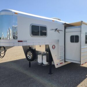 A 2017 Platinum Coach 4-horse gooseneck trailer with a 12-foot, 8-inch living quarters, featuring a slide-out. The trailer has a polished aluminum exterior with graphics and is shown with the slide extended.
