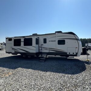 A used 2022 Jayco Eagle HT 312BHOK fifth wheel, a family-friendly bunkhouse model with a white and gray exterior. The RV has an outdoor kitchen, multiple slide-outs, and a prominent front cap.