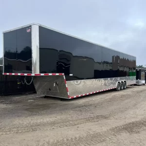 A new 2024 Quality Gooseneck Trailer, a long, black or dark gray flatbed trailer with a gooseneck hitch. The trailer is 52 feet long and 8.5 feet wide, with tandem axles and dual rear wheels.
