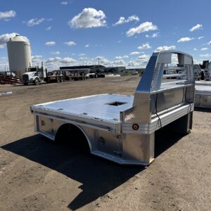 A Hillsboro 4000 Series Aluminum Truck Bed, a sleek and durable flatbed with a bright, polished aluminum finish. The bed has a diamond plate floor, a gooseneck hitch, and a protective headache rack with integrated lights.